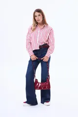 Camisa de manga larga con diseño de rayas verticales en color blanco y negro, cuenta con cuello clásico, cierre frontal de botones y un bolsillo en el pecho.