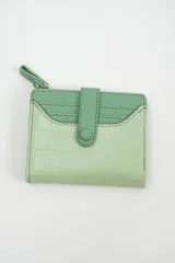 Billetera compacta de diseño bicolor en tonos verdes, con textura tipo cocodrilo en la parte inferior y cierre con solapa y botón a presión.