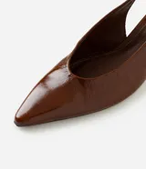 Zapatos slingback de cuero color marrón, con diseño destalonado, punta fina, taco kitten heel y tira elástica trasera.