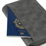 Billetera gris con cierre de cremallera, con el logo de la marca Baleine grabado en la parte inferior.