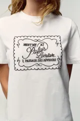 Camiseta blanca de manga corta y cuello redondo, con aplicación de organza y texto negro a contraste en el pecho.