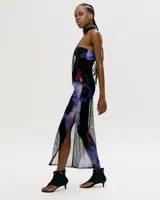 Vestido midi de tul transparente con estampado floral en tonos violeta, negro y rosa. Diseño sin mangas, corte ajustado y cuello choker.