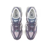 Championes urbanos New Balance modelo 9060, con diseño robusto y futurista en tonos violeta, gris y blanco. Presentan una combinación de materiales en gamuza y malla, con el logo N característico en los laterales y una suela gruesa con tecnología de amortiguación.