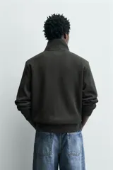 Chaqueta regular fit confeccionada en tejido interlock de algodón con elasticidad. Presenta cuello subido, manga larga, bolsillos de vivo en la cadera, acabados en rib y cierre frontal con cremallera.