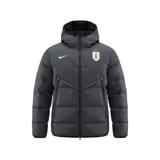 Campera puffer Nike de la selección uruguaya de fútbol, color gris oscuro, con capucha, cierre frontal completo y bolsillos laterales. Presenta el logo de Nike y el escudo de la AUF en el pecho.