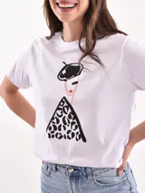 Remera blanca de manga corta y cuello redondo, con estampa frontal ilustrada de una mujer con boina y vestido con patrón animal print.