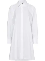 Vestido camisero de corte oversize confeccionado en algodón orgánico. Presenta cuello inglés, cierre frontal de botones, mangas largas con puños abotonados y largo hasta la rodilla. Incluye el logo de la marca bordado en el puño.