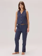 Chaleco negro sin mangas, de corte recto y largo a la cintura, con cuello redondo y cierre frontal oculto.