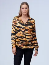 Blusa de gasa satén estampada con diseño animal print en tonos marrones y negros, escote en V y mangas largas con puños elásticos.