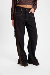 Jean de tiro alto con pierna recta y sutil amplitud en el bajo con tajo lateral. Presenta una cinta decorativa en el lateral, costuras en contraste y detalles de triple costura en los bolsillos delanteros y caderín trasero.