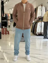 Campera azul marino de felpa con cierre frontal completo, cuello mao, bolsillos tipo canguro y logo bordado en el pecho.
