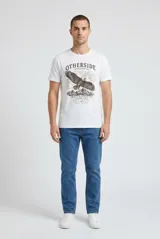 Remera blanca de manga corta y cuello redondo, confeccionada en algodón, con estampa frontal de un águila volando sobre montañas y la inscripción "Otherside Expedition Co. Andes Mountains Argentina".