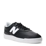 Championes New Balance modelo 080, color negro con detalles en blanco, incluyendo el logo "N" en los laterales. Presentan perforaciones en la puntera y una suela blanca.
