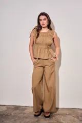 Blusa sin mangas de viscosa con estampado a cuadros vichy en tonos marrones y tostados, con doble fruncido elástico en el pecho y la cintura que genera un sutil vuelo inferior.