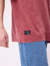 Remera de algodón con calce oversize, color negro con efecto lavado. Presenta un estampado gráfico en la espalda con diseño de espiral en tonos rosado y celeste, acompañado de inscripciones decorativas.