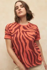 Remera de manga corta color naranja con estampado de cebra en color marrón.