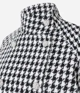 Saco corto estructurado con estampado pied de poule en blanco y negro. Presenta cuello alto, cierre frontal cruzado con botones decorativos y mangas largas.