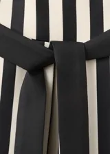 Vestido midi de corte evasé con diseño de rayas verticales en blanco y negro, escote palabra de honor y detalle de cinturón fino en la cintura.