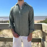 Camisa de lino color verde, con corte boxy, cuello clásico y cierre frontal con botones.