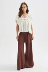 Pantalón de viscosa color marrón, con pinzas delanteras, tiro alto y corte ancho.