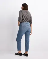Pantalón de jean de corte recto y tiro medio, con diseño clásico de cinco bolsillos y cierre frontal con botón y cremallera. Presenta un acabado en tono azul medio con sutiles desgastes.