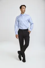 Camisa de vestir blanca de corte clásico, con cuello rígido, cierre frontal de botones y mangas largas con puños abotonados.