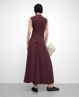 Pantalón palazzo bordó de tejido plisado (crinkle), con cintura elástica y godets centrales en delantero y espalda que aportan amplitud y movimiento.