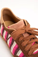 Zapatillas de estilo retro con diseño de rayas en tonos rosa, blanco y marrón. Combinan detalles en gamuza marrón y suela de goma con relieve.