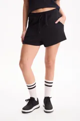 Short negro de corte suelto en tela soft modal liviana, con tiro medio-alto, cintura elástica ajustable con cordón y bolsillos laterales.