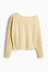 Buzo corto de punto fino suave color amarillo, con escote asimétrico y puños acanalados.