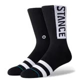 Medias negras de caña alta marca Stance, con franjas blancas en la puntera y un panel blanco vertical con la inscripción de la marca en el lateral de la pantorrilla.