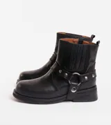 Bota corta negra de cuero vacuno con estribo desmontable, suela de caucho, cierre interno y punta redonda.