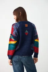 Sweater de tejido de punto con diseño geométrico multicolor sobre base azul marino, cuello redondo y puños acanalados.