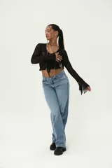 Top de manga larga negro de encaje con escote en V y terminación de encaje festoneado en el ruedo y escote.