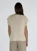 Top tejido color crudo con escote en V y mangas cortas con detalle de encaje.
