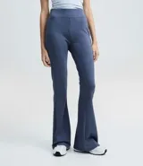 Pantalón flare de tiro alto con cintura ancha, confeccionado en microfibra elástica. Presenta un corte ajustado en caderas y muslos con una silueta acampanada desde la rodilla.
