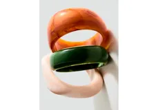 Pulsera tipo brazalete rígido de resina acrílica con acabado liso y brillante.