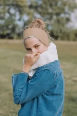 Vincha color beige con interior de corderito blanco, reversible y ajustable con velcro.