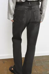 Jeans de tiro medio y corte recto, confeccionados en algodón con efecto lavado en tono gris oscuro. Presentan cintura con trabillas, cierre frontal con cremallera y botón, y diseño clásico de cinco bolsillos.