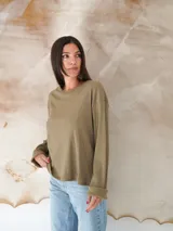 Remera de manga larga color verde oliva, con cuello redondo y tejido acanalado.