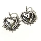 Par de aros colgantes plateados con forma de corazón con rayos.