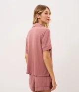 Pijama corto Lov de modal y elastano, color rosado con sutiles rayas verticales y acabado texturizado. Consta de una camisa de manga corta con cuello solapa, botones frontales y un bolsillo en el pecho, acompañada de un short con cintura cómoda.
