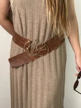 Cinturón ancho de cuero vacuno color marrón con hebilla de bronce con diseño abstracto.