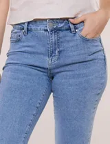Jean skinny de tiro medio con calce ajustado, cintura con presillas y acceso frontal con cierre y botón metálico. Presenta diseño clásico de cinco bolsillos y pierna entallada de largo al tobillo.