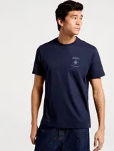 Camiseta blanca de algodón con cuello redondo y mangas cortas. Estampa rectangular con borde negro que contiene la frase "NATURAL ATMOSPHERE" en letras mayúsculas y una imagen de montañas y mar.
