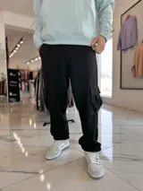 Pantalón cargo de jean azul claro, con bolsillos laterales tipo cargo en las piernas y bolsillos frontales aplicados, de corte ancho y holgado.
