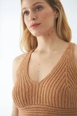 Top tejido de punto color tostado, con escote en V, diseño de espalda cruzada y ajuste al cuerpo.