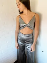 Top plateado de lamé elastizado con breteles finos y escote en V cruzado.