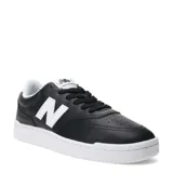 Championes urbanos New Balance de estilo court, color negro con detalles en blanco. Presentan el logo 'N' en el lateral, puntera perforada y suela de goma blanca.