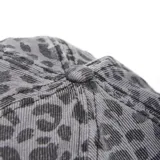 Gorro tipo cap con visera curva, confeccionado en tela gris con estampado animal print de leopardo y detalles de desgaste en el borde de la visera.